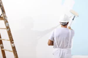 Man using a roller to paint walls